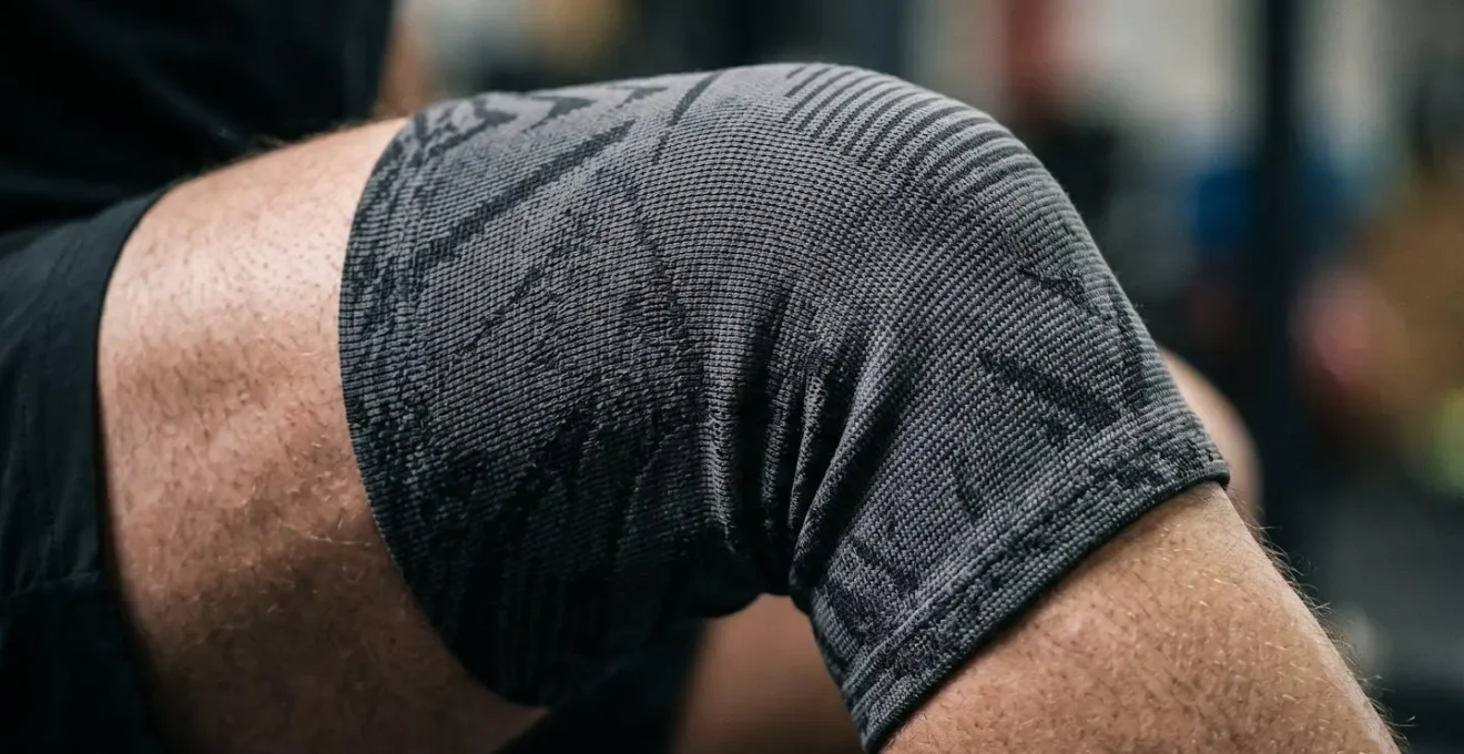 Gros plan sur articulation du genou avec bandage de compression lors d'un mouvement sportif