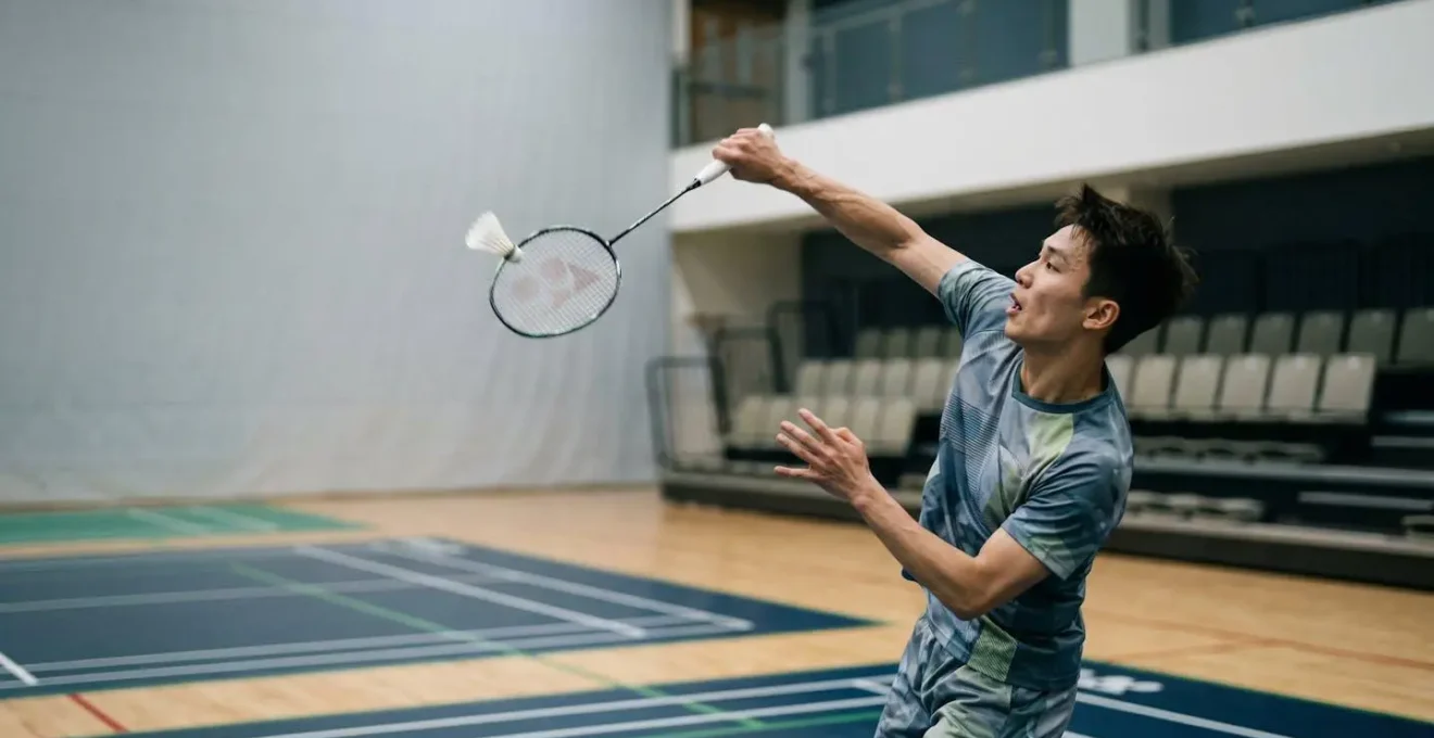 Joueur de badminton en plein smash avec rotation explosive du buste et pronation de l'avant-bras