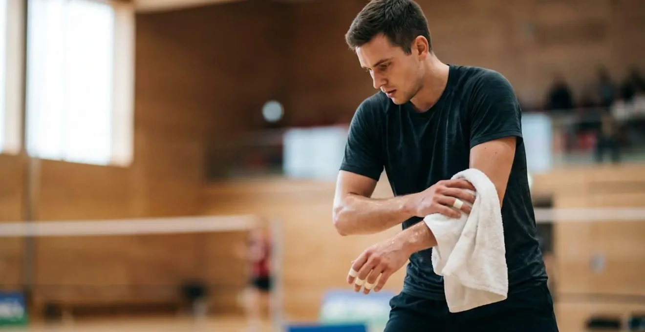 Joueur de badminton utilisant une serviette pendant une pause entre les points