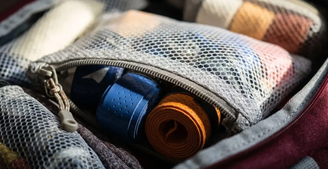 Gros plan sur les compartiments organisés d'un sac de badminton avec accessoires