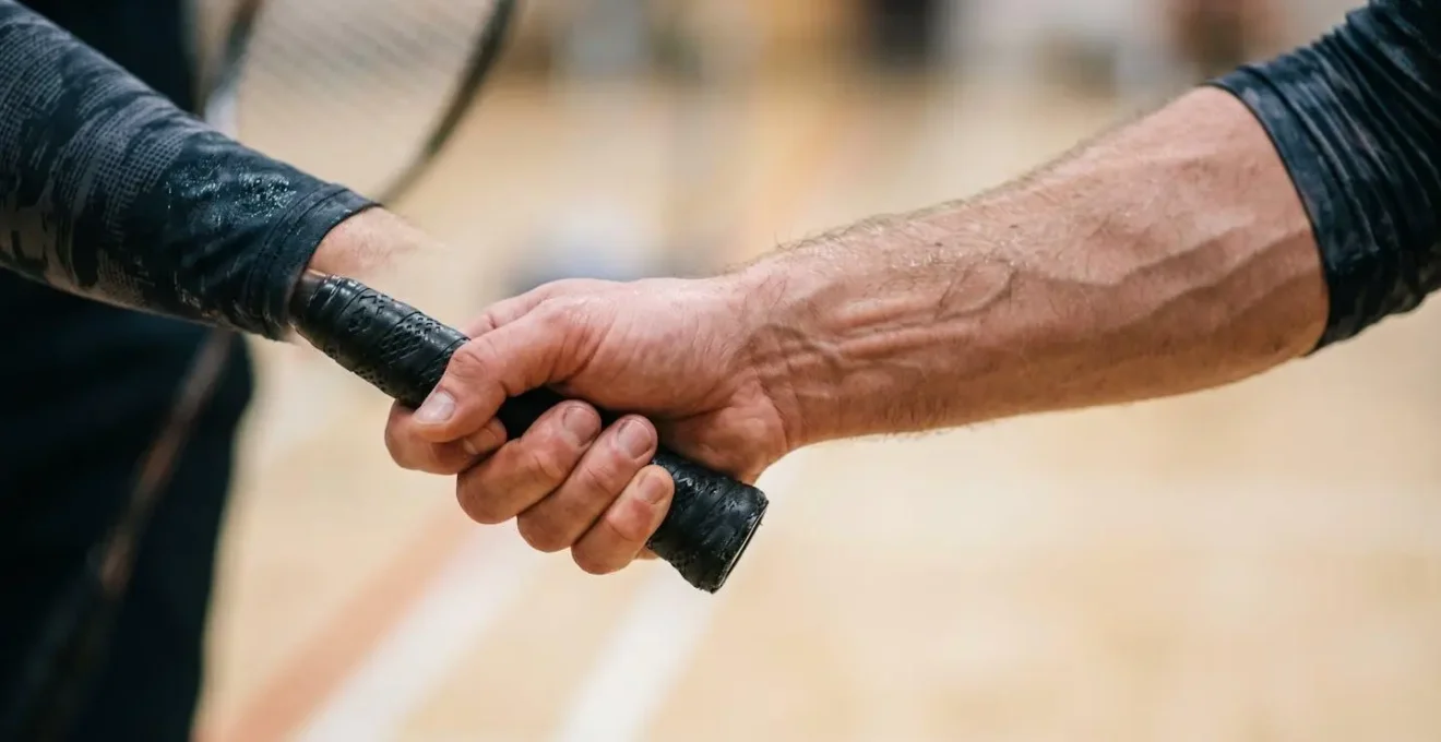 Gros plan sur la rotation de l'avant-bras lors d'un mouvement de pronation au badminton illustrant la technique du smash