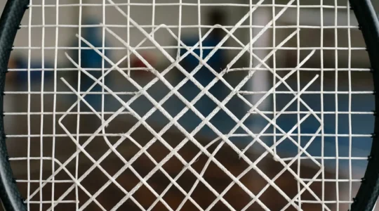 Gros plan sur le cordage d'une raquette de badminton professionnelle avec zone de centrage visible